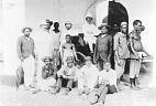  
Code: 0002 4045
Category: People from Elmina

The Dutch factory in Elmina, with European and African personnel

Between circa 1888 and 1894, the firm of Gebroeders Ter Meulen of Rotterdam ran a factory, mainly trading in palm oil. The firm left Elmina during the worldwide agricultural crisis, which cut profits severely.
The photo shows three European staff (among whom probably one or two Ter Meulen's), three African agents (standing) some clerks (sitting), and manual labourers and carriers. The photo is taken in front of the Viala Houses, a merchant's house in Liverpool Street. This house was rented by the firm.

