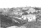  
Code: 0002 4043
Category: Views of Cape Coast

1. View of Cape Coast towards the South, from Lighthouse Hill

It is likely that Hendrik Muller visited Cape Coast after he visited Elmina. Cape Coast is the former British Capital of the Gold Coast, situated circa 15 kilometres east of Elmina. All photo's of Cape Coast show views of the town and were most likely bought by him.

In the foreground one sees a large merchants' house at the foot of the hill. Behind that is Government House, the Methodist Chapel with square tower, and Cape Coast Castle. Behind Government House and another private house one can just see the low round tower of the Anglican Church. On the left of the photo a number of merchants' houses is visible situated in the business centre of the town (Commercial Street). Of further note are the many swish (clay) houses with flat roofs.
